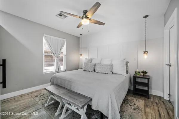 a bedroom with a bed a chandelier and a window