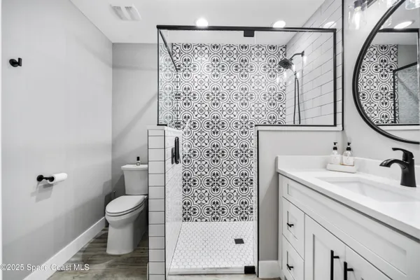 a bathroom with a sink a toilet and shower