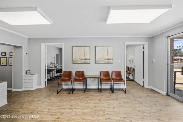 a living room with chairs and a table with rug