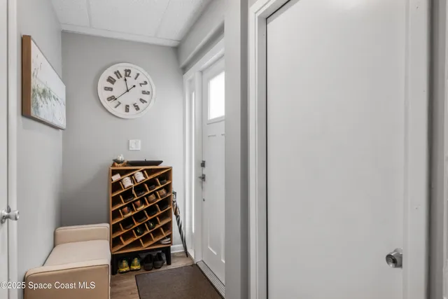a view of a hallway with front door with wooden floor