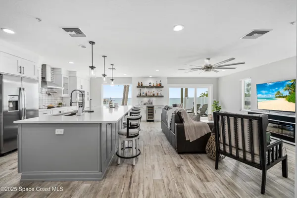 a living room with furniture a rug and kitchen view