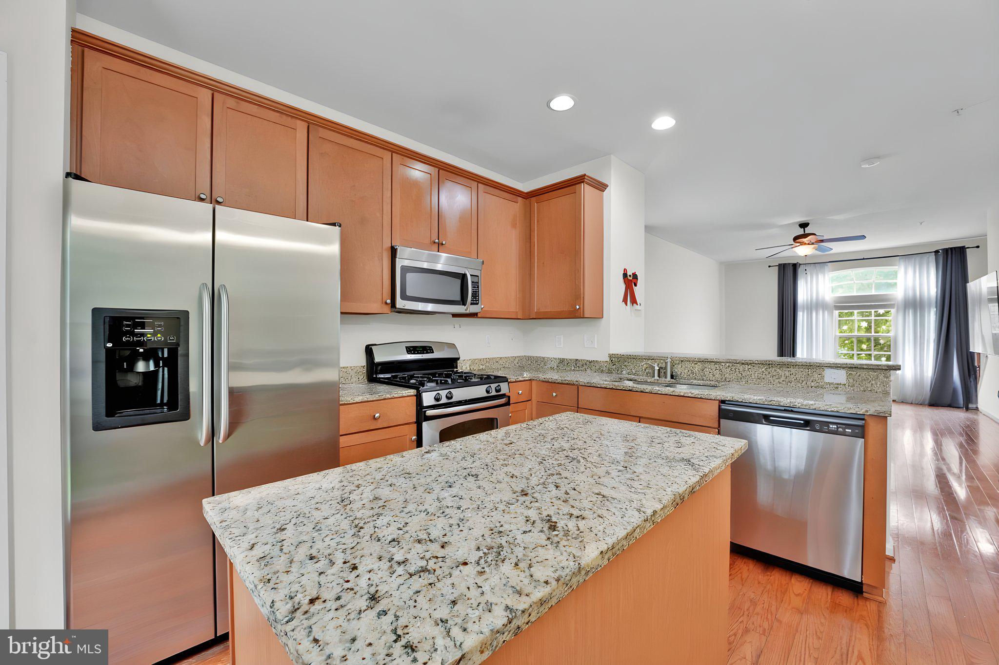 7138 Station House Road Elkridge, MD 21075 - Photo 27 of 42 a kitchen with stainless steel appliances granite countertop a refrigerator stove microwave and sink