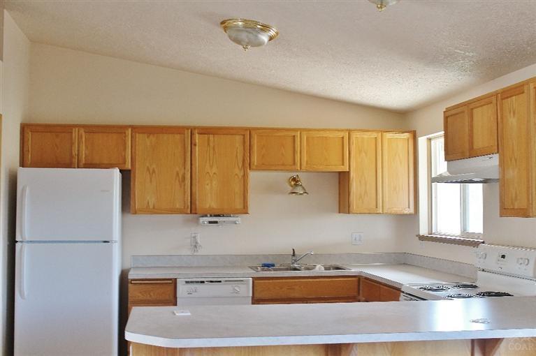 19221 Shoshone Road Bend, OR 97702 - Photo 12 of 15 a kitchen with a sink a refrigerator and cabinets
