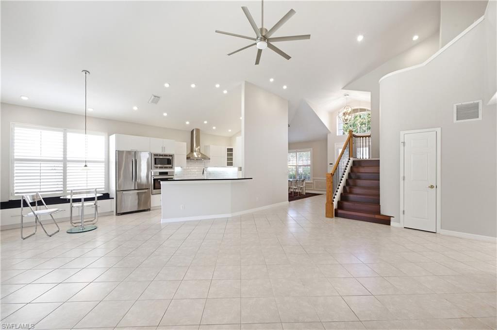 1960 Timarron Way Naples, FL 34109 - Photo 8 of 45 Spacious open-concept living area featuring a vaulted ceiling and tile flooring
