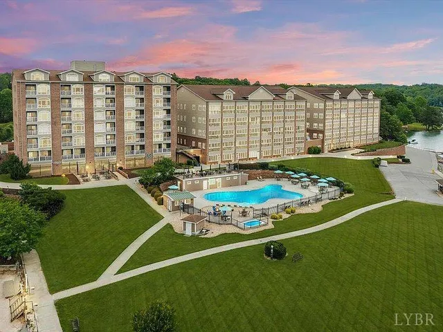 a view of a large pool with lawn chairs and a big yard