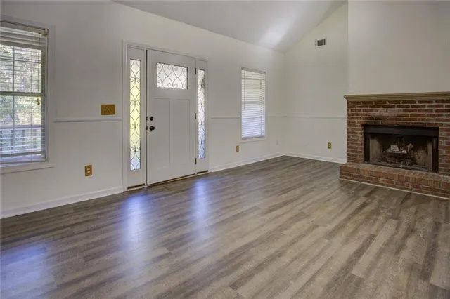 an empty room with large windows and white walls