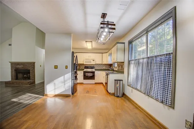 a kitchen with stainless steel appliances granite countertop a refrigerator a stove and a sink