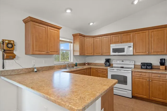 a kitchen with stainless steel appliances granite countertop a sink stove and cabinets