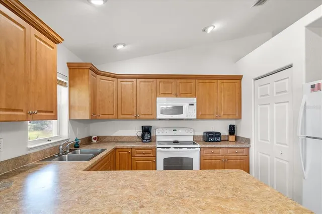 a kitchen with stainless steel appliances a sink a stove a microwave a sink and cabinets
