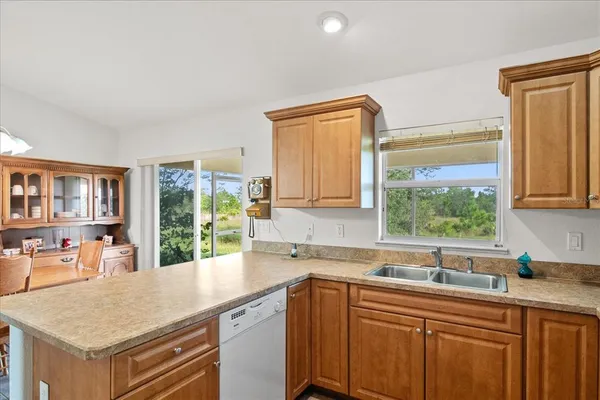 a kitchen with stainless steel appliances granite countertop a sink and a large window