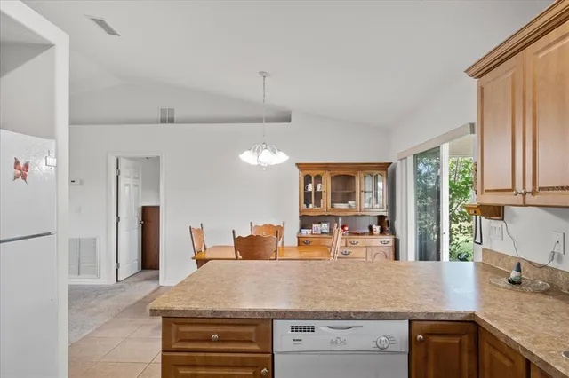 a kitchen with kitchen island a counter top space a sink a refrigerator and a large window