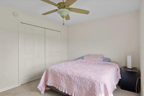 a bedroom with a bed and a ceiling fan