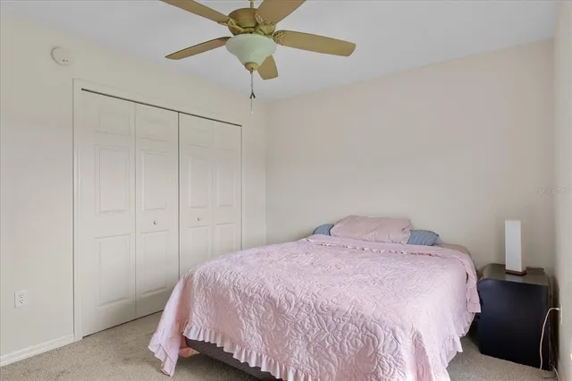 a bedroom with a bed and a ceiling fan