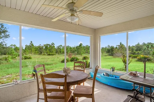 a view of a chairs and table in patio with a yard