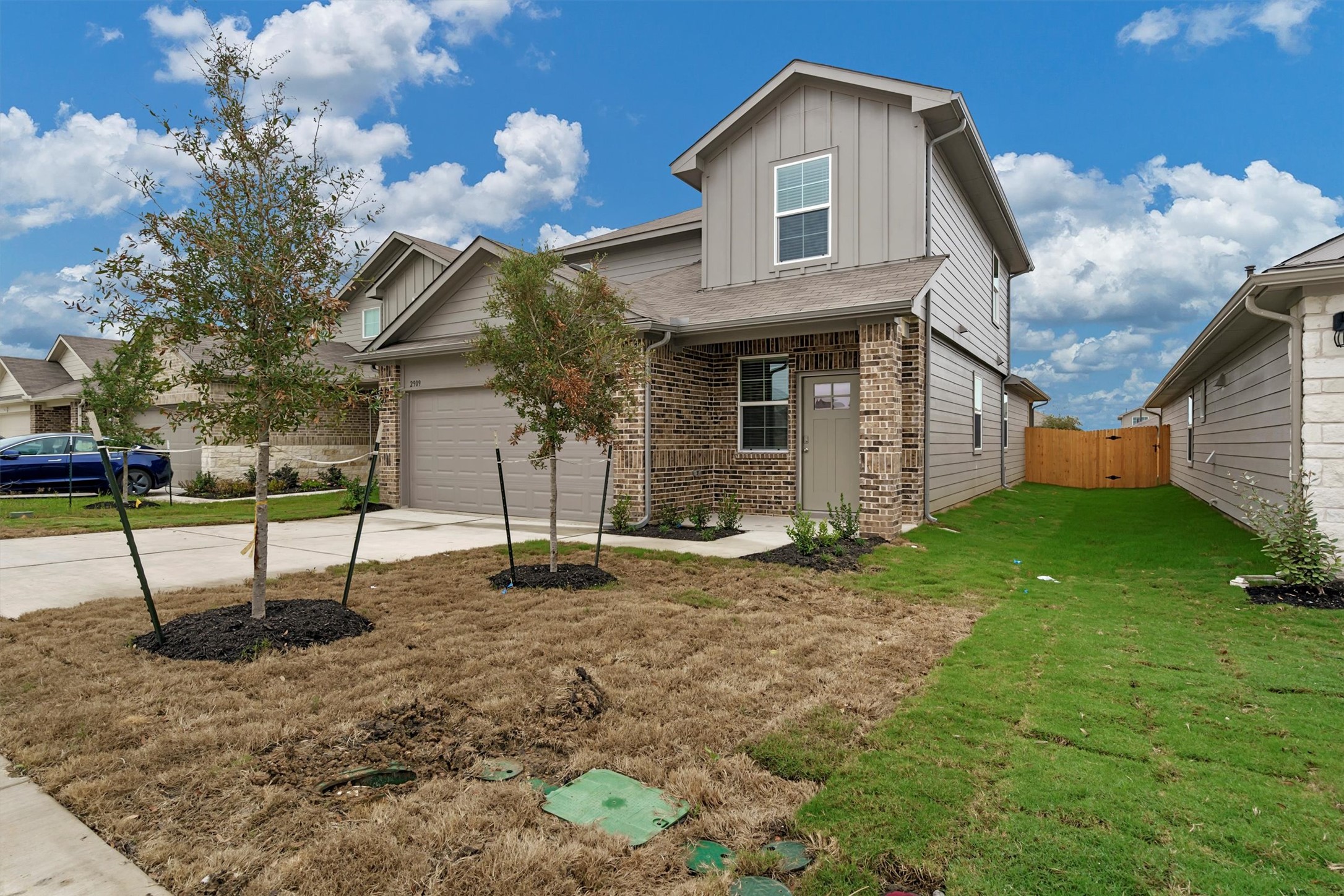 2909 Tweedy Trail Pflugerville, TX 78660 - Photo 5 of 27 A new construction home with brick and siding facade awaits, featuring a fenced side yard and an attached garage.