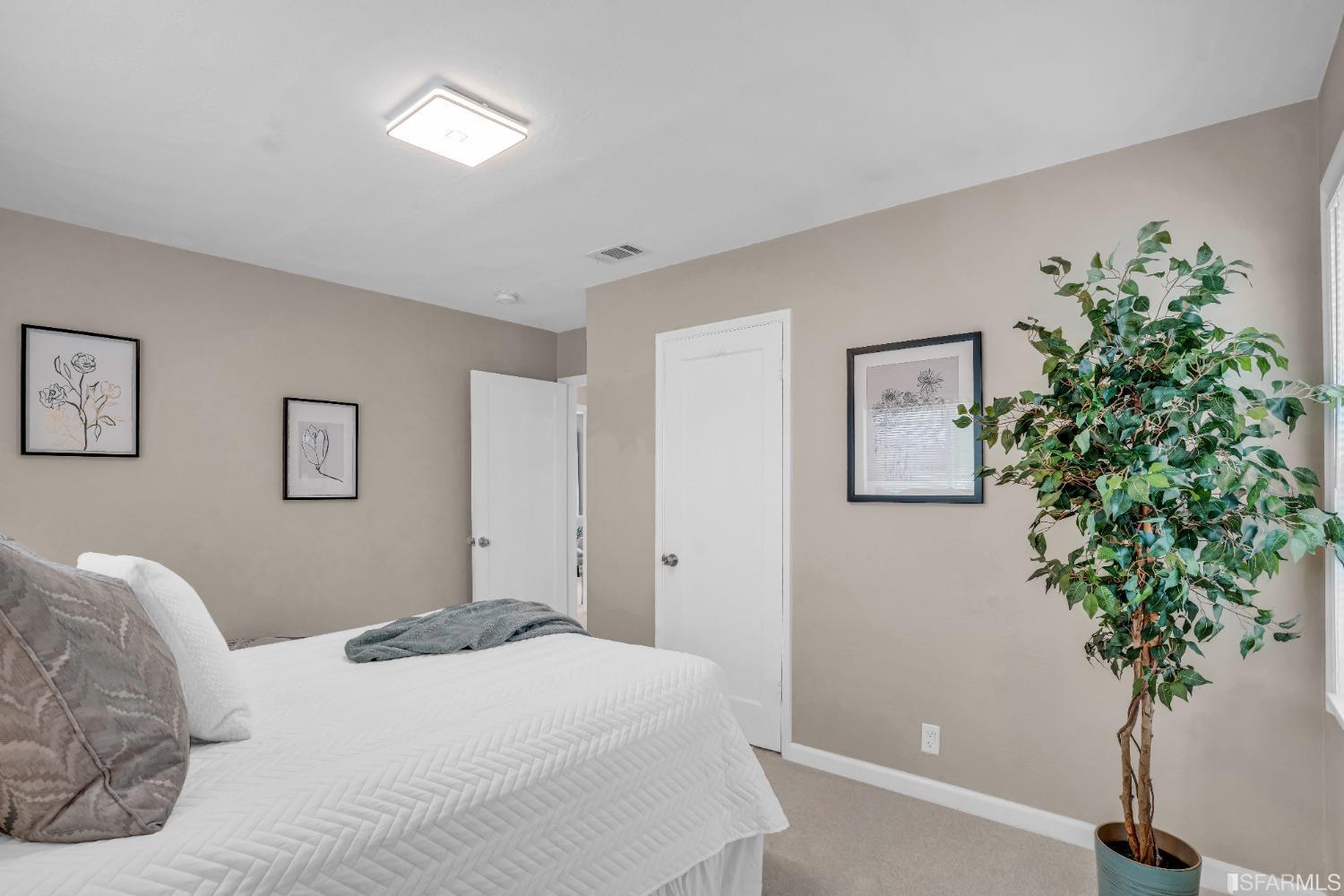 476 Violet Street San Leandro, CA 94578 - Photo 18 of 30 a bedroom with a large bed plant and a potted plant