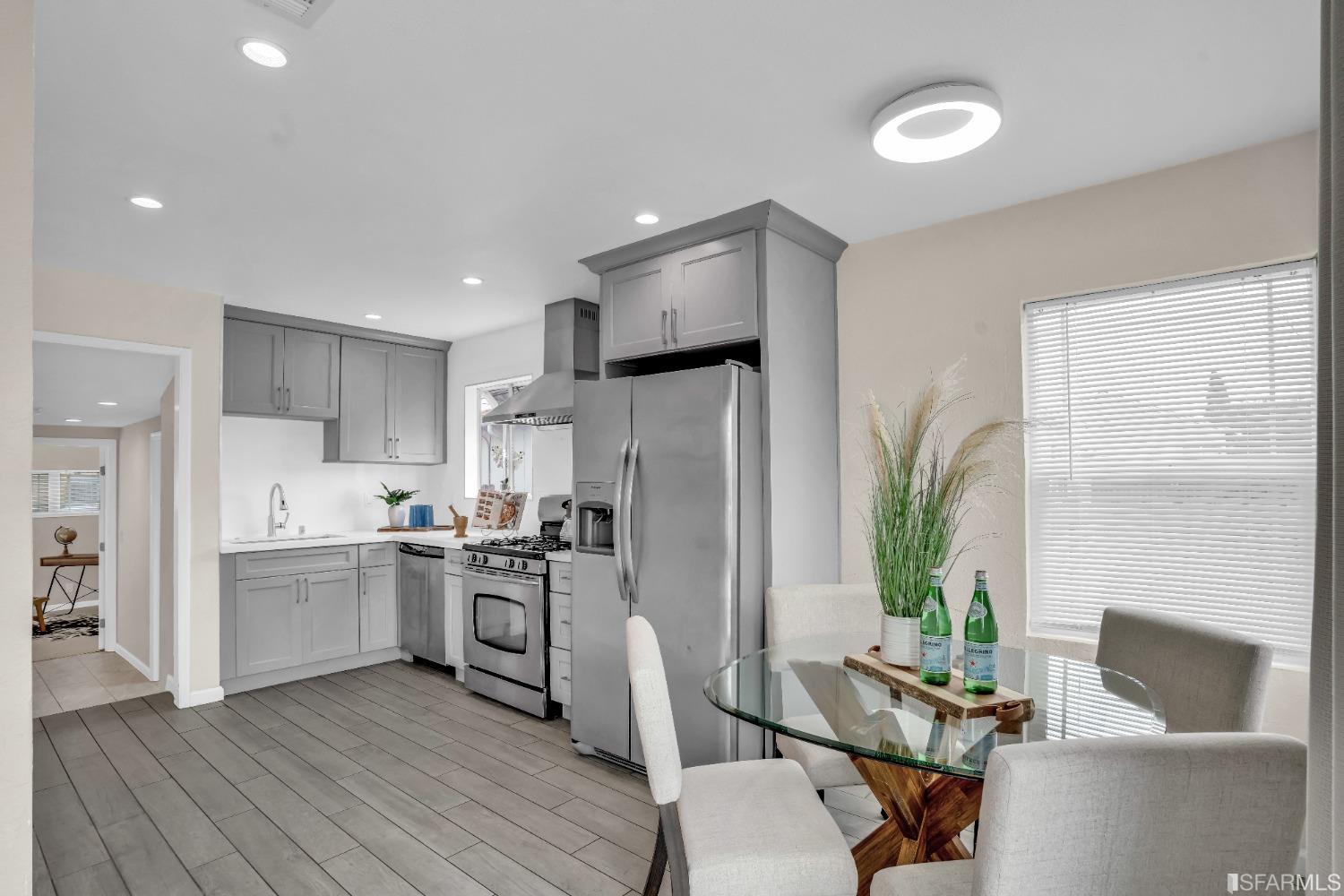 476 Violet Street San Leandro, CA 94578 - Photo 7 of 30 a kitchen with stainless steel appliances a refrigerator a stove a sink and white cabinets with wooden floor