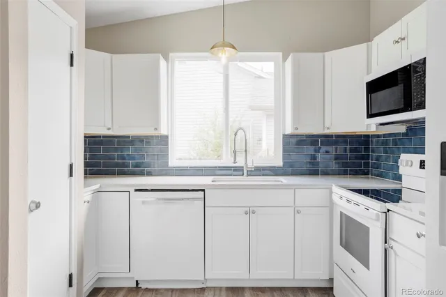 a kitchen with stainless steel appliances granite countertop a sink and a stove