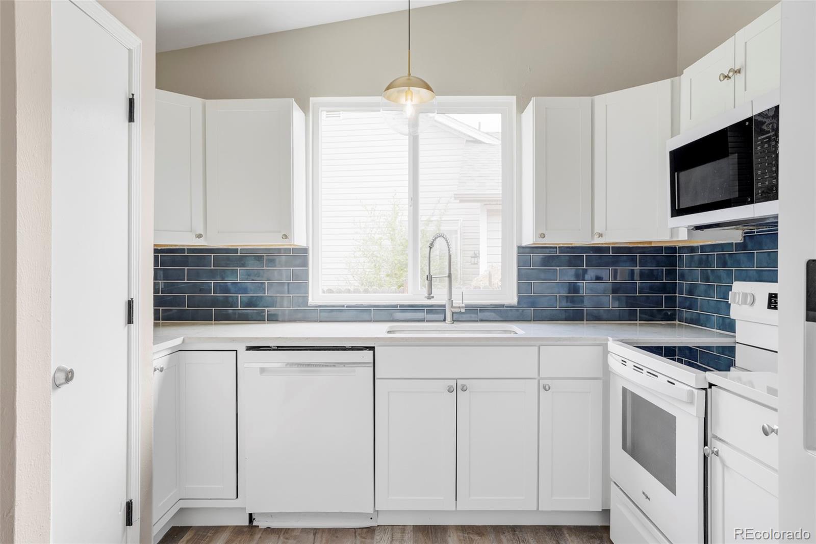 4345 Eagle Street Denver, CO 80239 - Photo 3 of 20 a kitchen with stainless steel appliances granite countertop a sink and a stove
