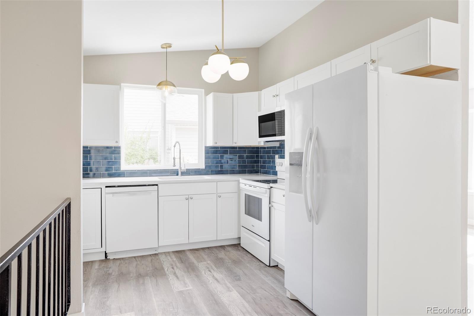 4345 Eagle Street Denver, CO 80239 - Photo 4 of 20 a kitchen with a refrigerator and a sink