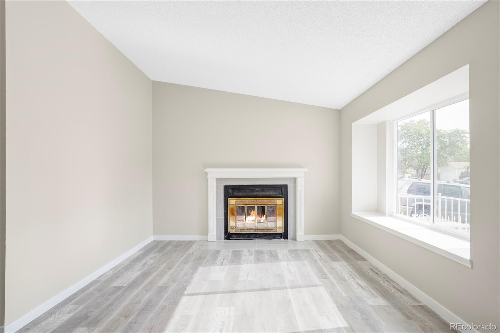 4345 Eagle Street Denver, CO 80239 - Photo 5 of 20 a view of an empty room with a window and a fireplace