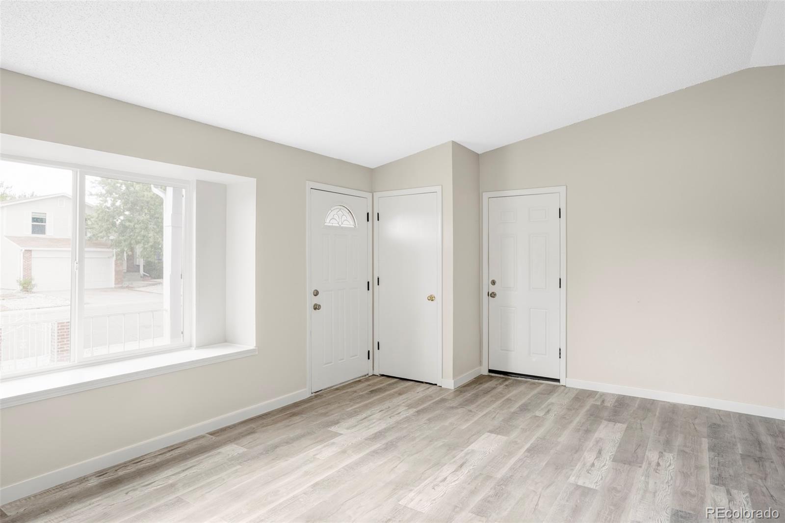 4345 Eagle Street Denver, CO 80239 - Photo 6 of 20 a view of empty room with wooden floor and fan