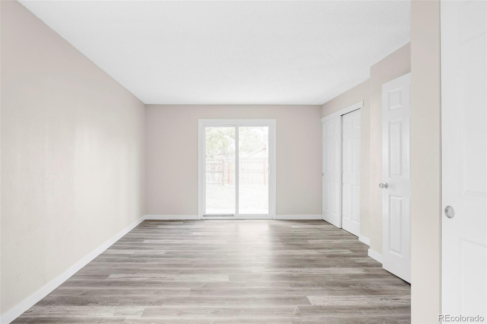 4345 Eagle Street Denver, CO 80239 - Photo 10 of 20 a view of an empty room with wooden floor and a window