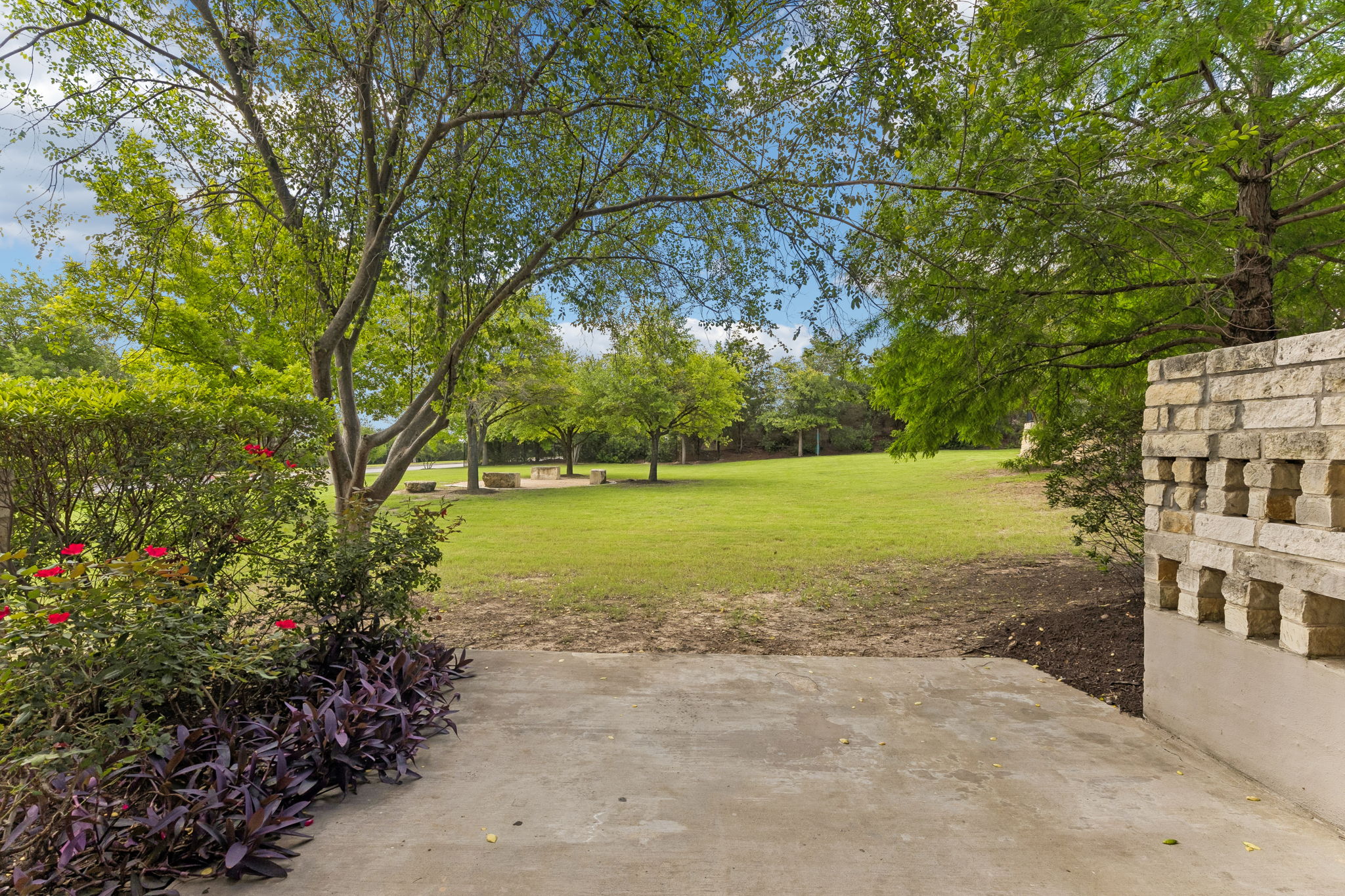 114 Aria Ridge, Unit 802 Lakeway, TX 78738 - Photo 2 of 37 Green landscaping and mature trees frame a vast lawn, offering natural serenity.