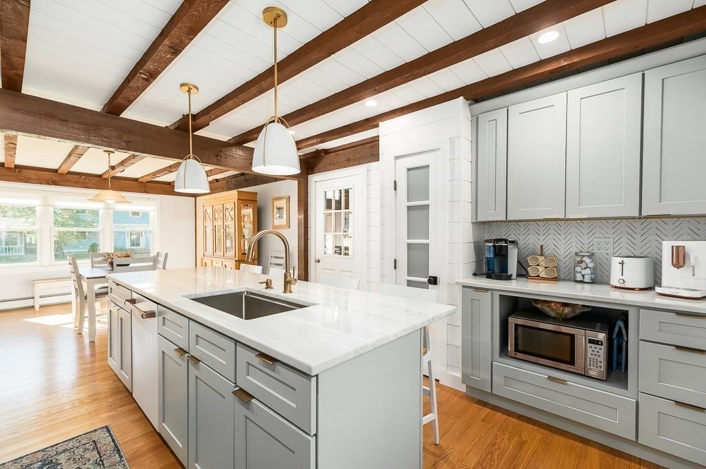 28 Macomber Road Gloucester, MA 01930 - Photo 20 of 40 a kitchen with granite countertop a sink and white cabinets