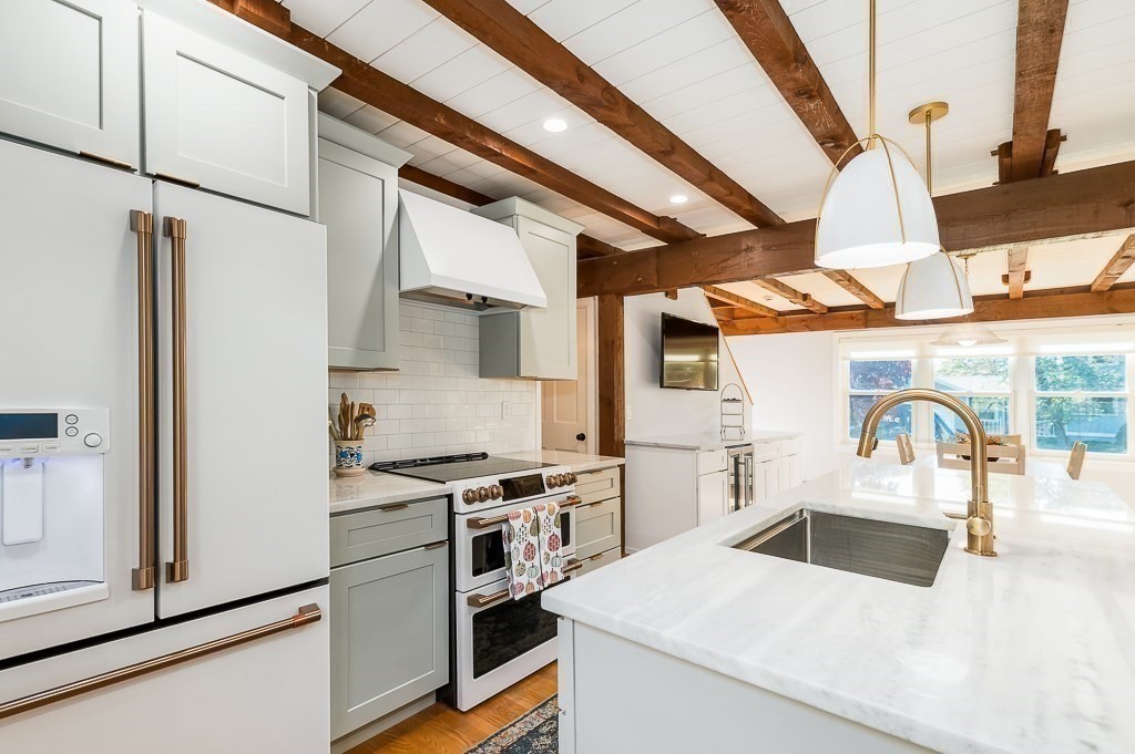 28 Macomber Road Gloucester, MA 01930 - Photo 21 of 40 a kitchen with stainless steel appliances kitchen island a stove a refrigerator and cabinets
