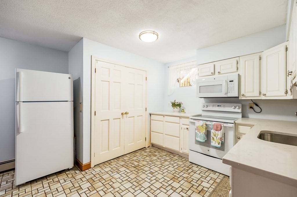 28 Macomber Road Gloucester, MA 01930 - Photo 34 of 40 a kitchen with stainless steel appliances granite countertop a refrigerator sink and white cabinets