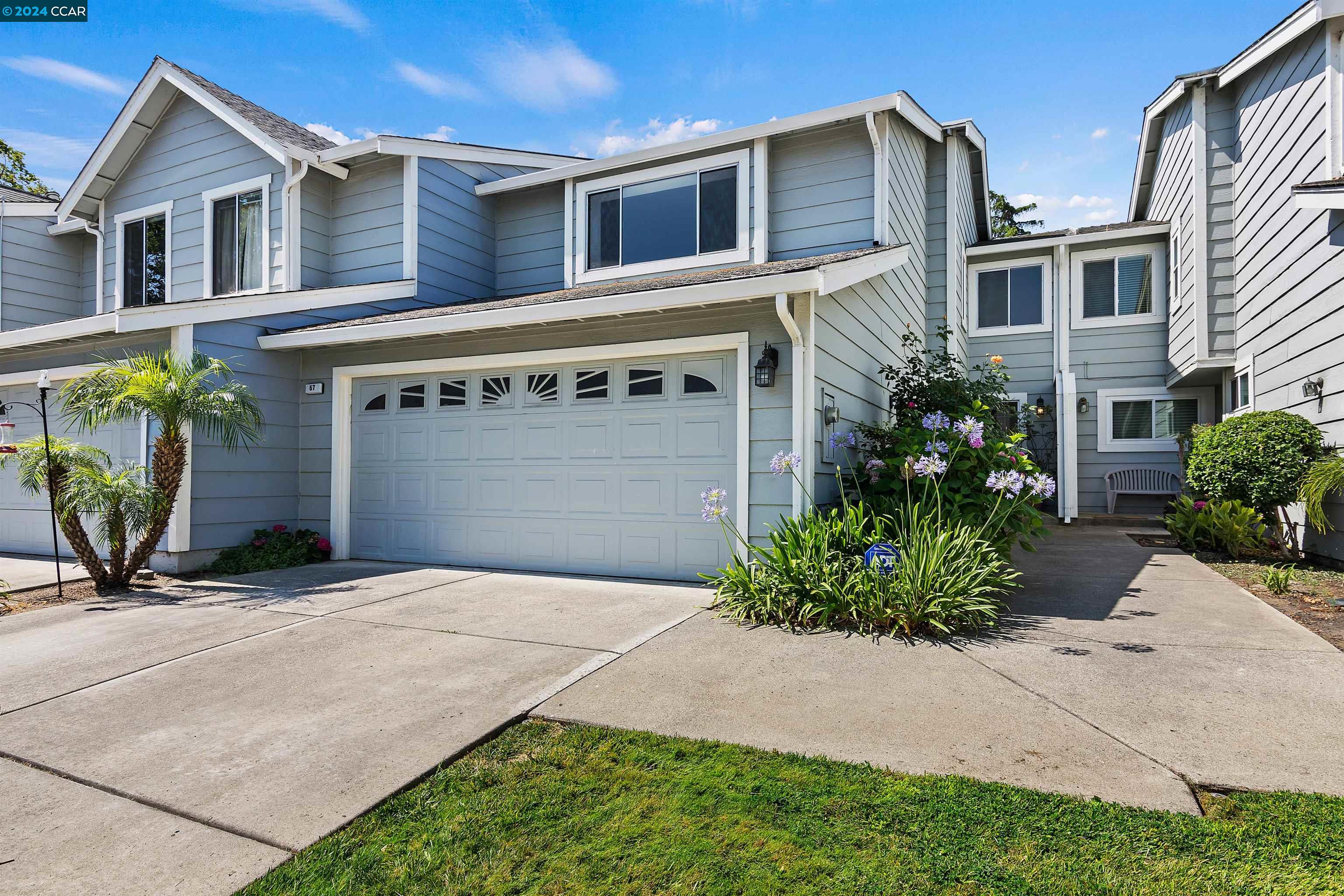 a front view of a house with garden and plants