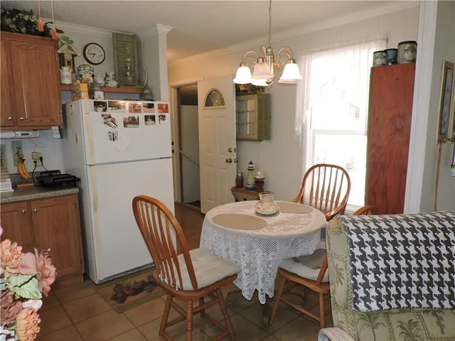 a kitchen with stainless steel appliances granite countertop a dining table chairs a refrigerator and a sink