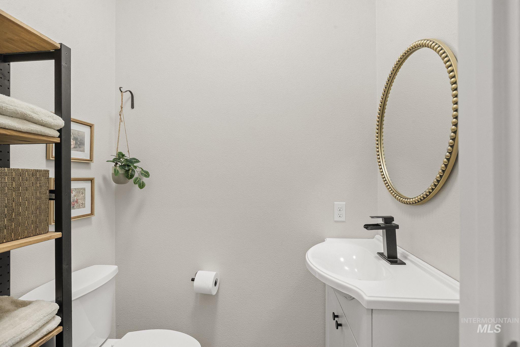 602 Quarry Road Asotin, WA 99402 - Photo 21 of 49 White vanity with integrated sink, matte black faucet, and a decorative gold-framed oval mirror