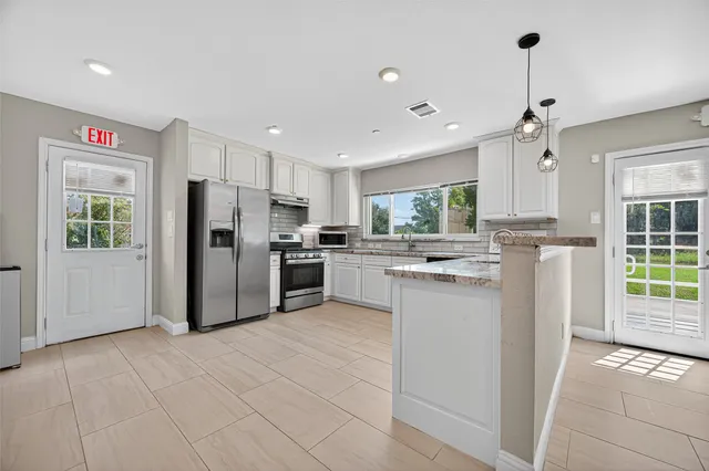 a kitchen with stainless steel appliances a refrigerator sink and cabinets