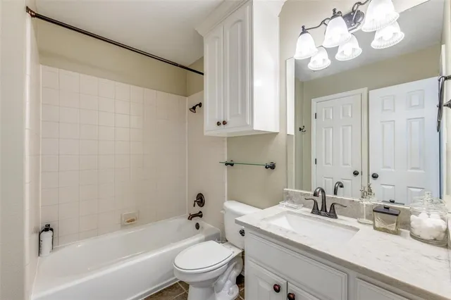 a bathroom with a granite countertop sink a toilet and bathtub