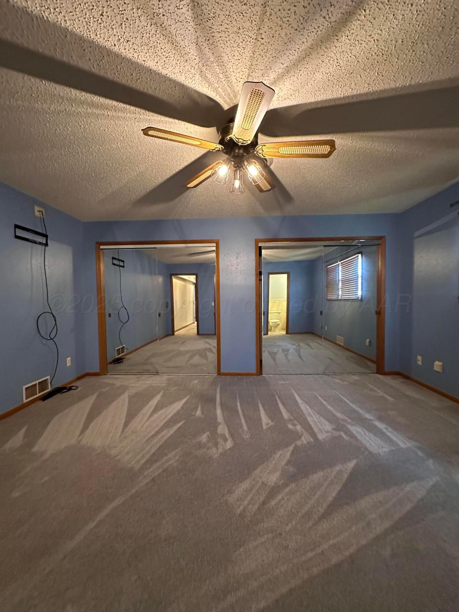 1007 Archer Street Spearman, TX 79081 - Photo 11 of 20 a view of an empty room with window and a ceiling fan