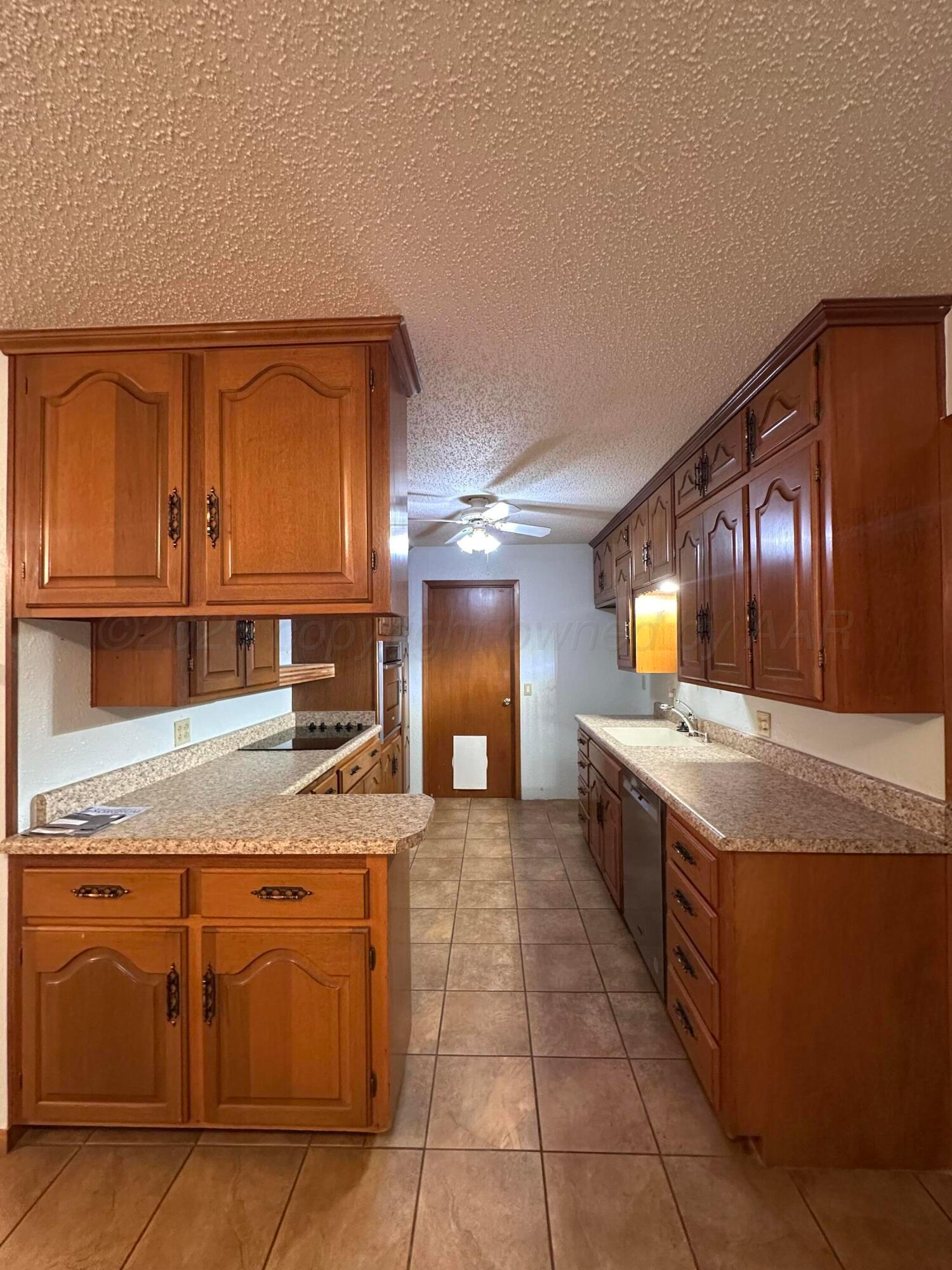1007 Archer Street Spearman, TX 79081 - Photo 4 of 20 a large kitchen with kitchen island granite countertop a sink and a stove