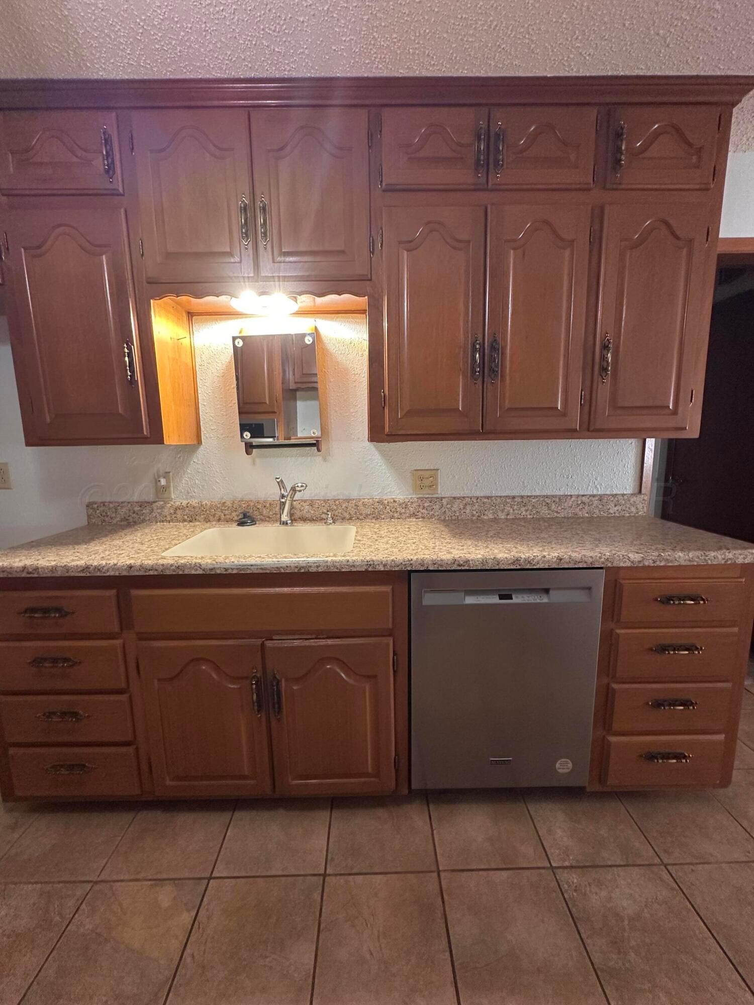 1007 Archer Street Spearman, TX 79081 - Photo 7 of 20 a kitchen with granite countertop cabinets and window