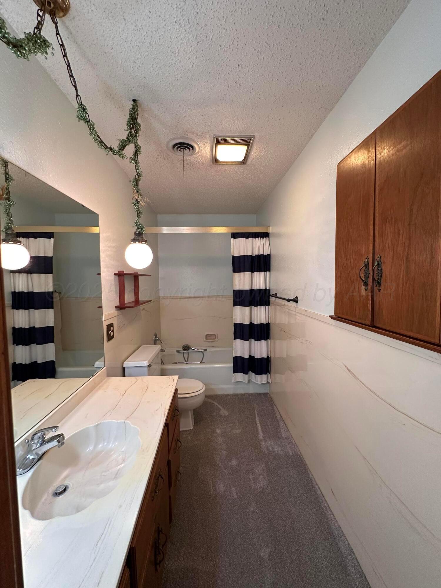 1007 Archer Street Spearman, TX 79081 - Photo 10 of 20 a bathroom with a sink a vanity and a shower