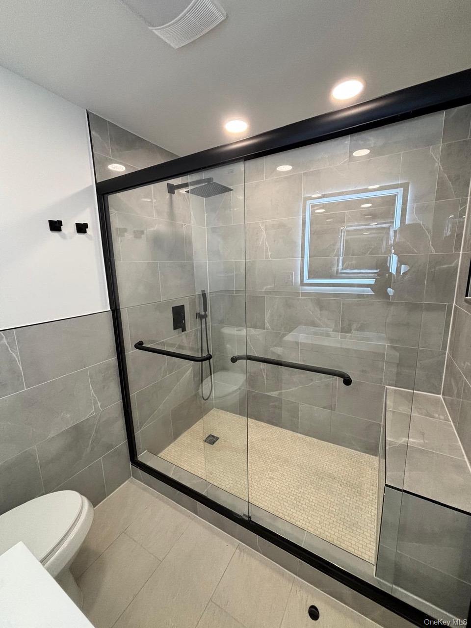 791 Longview Avenue Valley Stream, NY 11581 - Photo 16 of 33 Full bathroom with a shower stall, tile walls, and light tile patterned flooring
