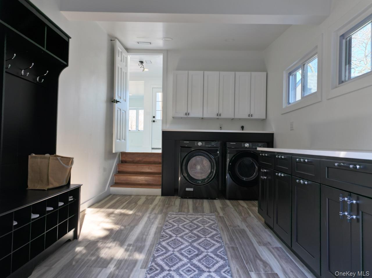 791 Longview Avenue Valley Stream, NY 11581 - Photo 29 of 33 Laundry area with separate washer and dryer, light wood-style floors, and cabinet space