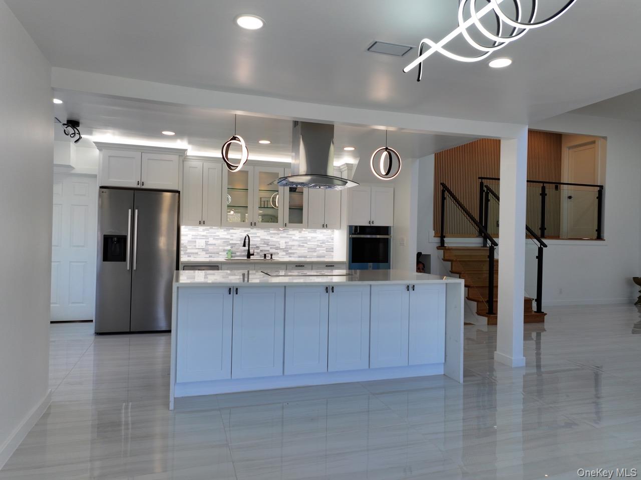 791 Longview Avenue Valley Stream, NY 11581 - Photo 31 of 33 Kitchen featuring stainless steel appliances, glass fronted cabinets, island exhaust hood, a spacious island, and white cabinets