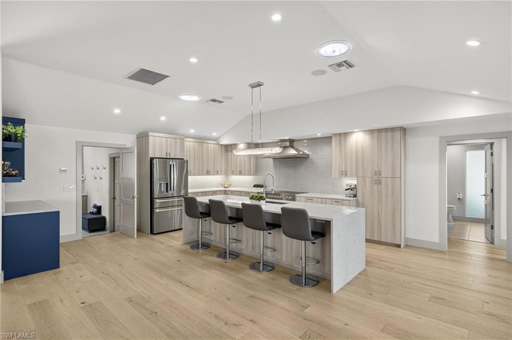 5215 Seashell Avenue Naples, FL 34103 - Photo 14 of 47 a kitchen with stainless steel appliances kitchen island granite countertop a refrigerator and a stove top oven