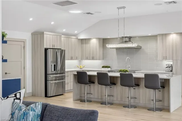 a kitchen with stainless steel appliances a dining table chairs stove and white cabinets