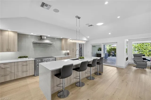 a kitchen with a dining table chairs cabinets and stainless steel appliances