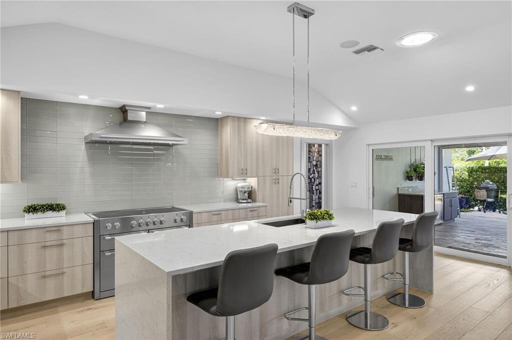 5215 Seashell Avenue Naples, FL 34103 - Photo 21 of 47 a kitchen with a dining table chairs cabinets and stainless steel appliances