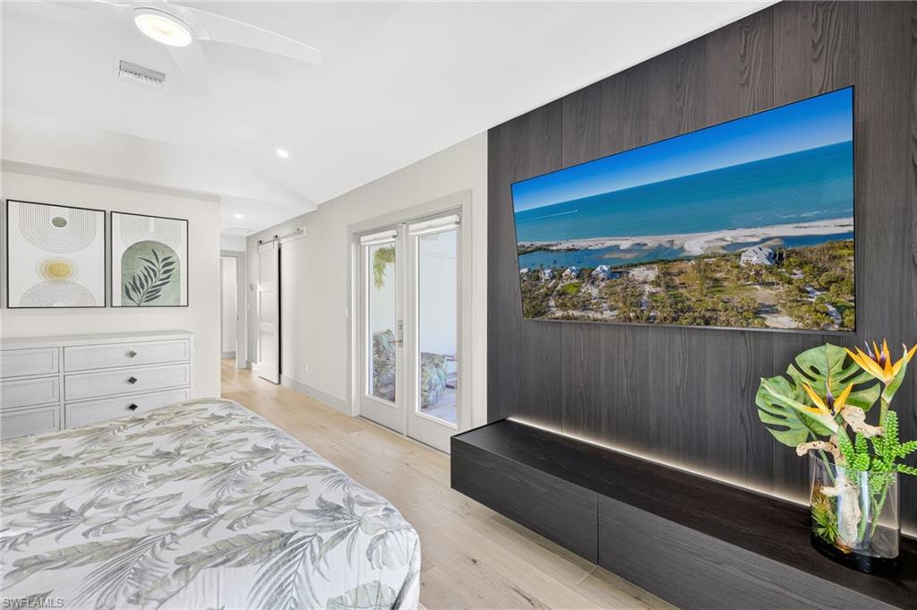 5215 Seashell Avenue Naples, FL 34103 - Photo 24 of 47 a spacious bedroom with a bed and a painting on the wall