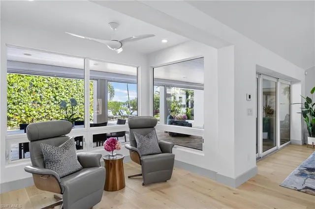a living room with a bed furniture flat screen tv and a large window
