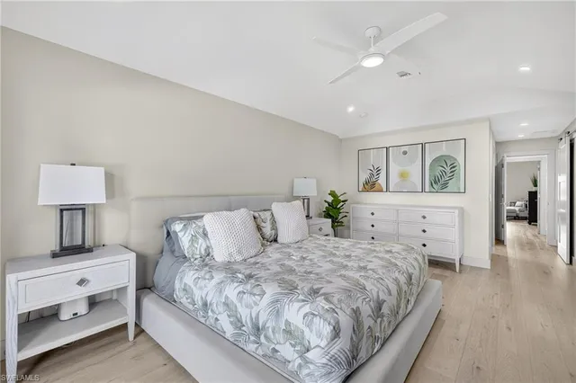 a bedroom with a bed and large windows